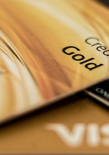 Stack of various branded credit cards focusing on gold card showing finance and cashless concept.